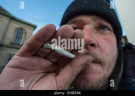 Un homme fumer un joint à l'aide de tabac et heureux joker, un haut juridique Banque D'Images