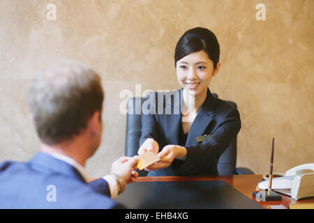 Japanese female concierge de l'hôtel traiter avec un client Banque D'Images