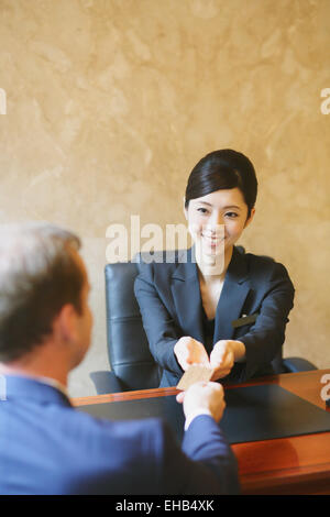 Japanese female concierge de l'hôtel traiter avec un client Banque D'Images