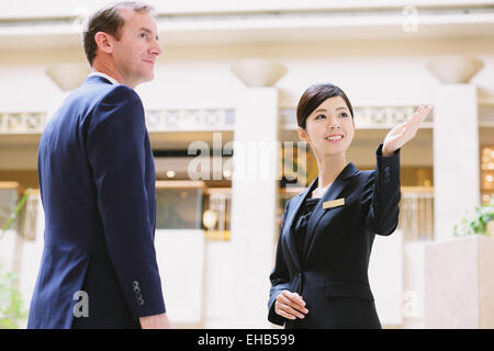 Japanese female concierge de l'hôtel traiter avec un client Banque D'Images