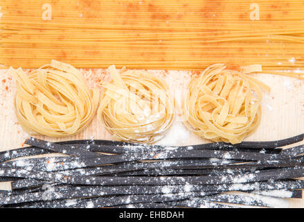 Still Life : spaghetti, pâtes noires, la farine sur la table en bois Banque D'Images