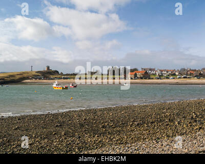 Vue sur Mer du Nord à l'abbaye de Lindisfarne ruines et maisons sur l'Île Sainte Northumberland England UK sur beau jour de mars Banque D'Images