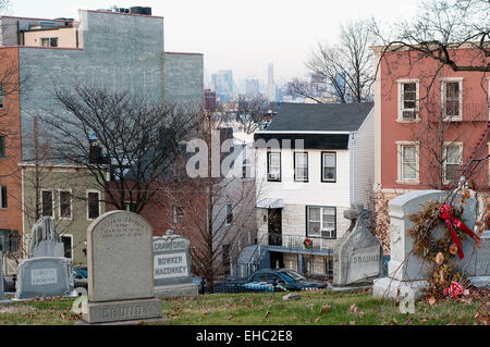 Les maisons bordant la pointe de Vert-bois cemetery de Brooklyn, New York. Vous pouvez voir Manhattan en arrière-plan. Banque D'Images