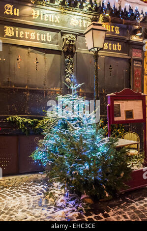 Petit arbre de Noël enneigé devant 'Au Vieux Strasbourg' restaurant fermé le soir sur l'époque de Noël Strasbourg Alsace France Europe Banque D'Images