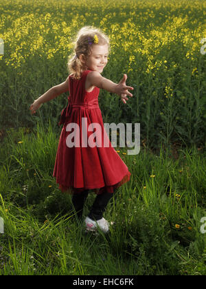 Une petite fille dansant sur une herbe Banque D'Images