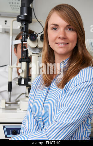 Opticien Femelle Mâle donnant l'examen des yeux du client Banque D'Images