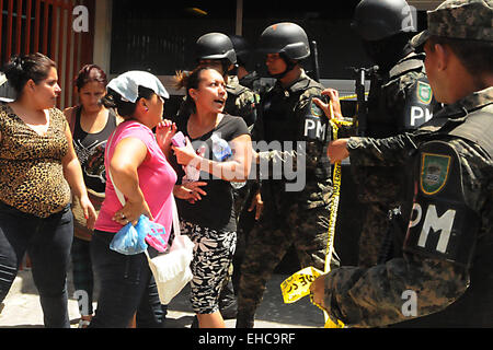 San Pedro Sula, au Honduras. Mar 11, 2015. Des proches des détenus parlent avec les policiers honduriens qui montent la garde dans les environs au cours d'une mutinerie des prisonniers dans le centre pénitentiaire de San Pedro Sula, dans le nord du Honduras, le 11 mars 2015. Au moins trois personnes sont mortes et plus de 30 ont été blessés pendant le tournage le mercredi dans le centre pénitentiaire de San Pedro Sula, au cours d'une émeute contre le transfert des détenus d'autres prisons réalisée pour les autorités du Honduras, selon la presse locale. Credit : Rafael Ochoa/Xinhua/Alamy Live News Banque D'Images