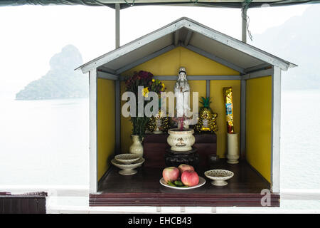 Au culte d'autel,offrant à ce sanctuaire bouddhiste pour le passage en toute sécurité à l'avant du bateau de tourisme,Ha long,Halong Bay, Vietnam Banque D'Images