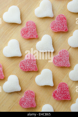 Gummy coeurs rouge et blanc en diagonale sur un bloc de boucher Banque D'Images