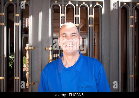 Madrid, Espagne. Mar 9, 2015. Portier de 62 ans, Rafael Cabrera Rapos, sourire alors qu'il se place devant la porte d'entrée d'un bloc de huit étages de l'immeuble d'appartements dans le quartier Hispanoamerica à Madrid, Espagne, le 9 mars 2015. Rapos travaille comme portier de 37 ans. Photo : Bianca Baer/dpa/Alamy Live News Banque D'Images