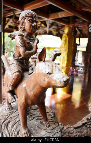 Sculpture sur bois de style thaï traditionnel comme un chien géant équestre de 12 zodiaque dans l'église de temple en Thaïlande. Banque D'Images