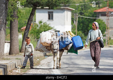 Woman and boy avec âne marchant le long d'une route de montagne, les montagnes du Taurus, Province de Konya, Turquie Banque D'Images