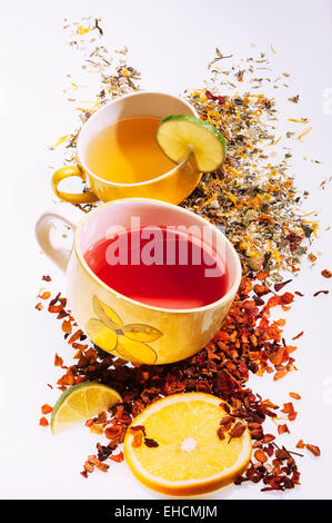 Des tasses avec les tranches de citron et divers thés de fruits, de feuilles de thé à côté de la tasse Banque D'Images