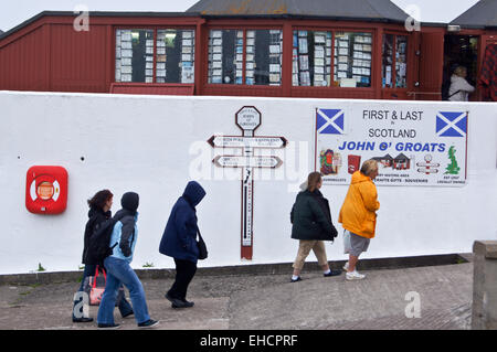 Les promeneurs passant l'enseigne l'affichage des distances à Land's End, John O'Groats, Caithness, Ecosse Banque D'Images