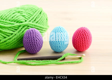 Les oeufs de Pâques dans le crochet vert, rose, bleu et violet Banque D'Images