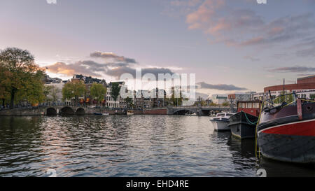 Coucher de ciel au-dessus de la rivière Amstel, à Amsterdam. Bateaux, de canaux, de ponts. Banque D'Images