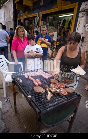 L'ARGENTINE, Buenos Aires, La Boca, femme la cuisson des viandes sur le barbecue extérieur parilla de Boca Juniors football stadium Banque D'Images