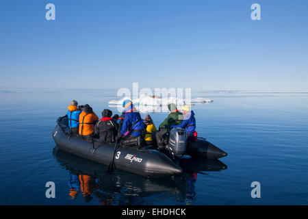 Les touristes en bateau gonflable homme regardant le morse (Odobenus rosmarus) reposant sur le banc de glace dans la mer Arctique, Svalbard, Norvège Banque D'Images