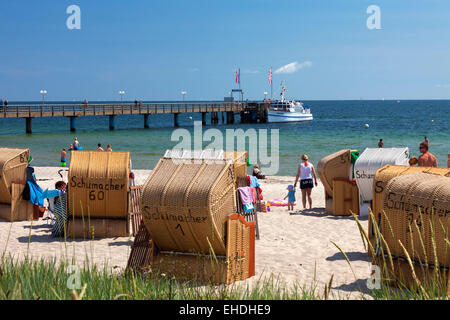 Pier et le soleil dans les chaises de plage à la station balnéaire Haffkrug, Schleswig-Holstein, Allemagne Banque D'Images