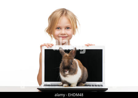 Petite fille avec ordinateur portable et bunny sur elle Banque D'Images