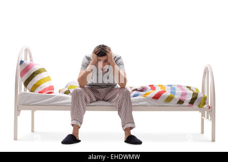 Jeune homme souffrant d'insomnie isolé sur fond blanc Banque D'Images