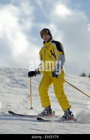 Skieur de montagne jaune sur la pente de ski Banque D'Images