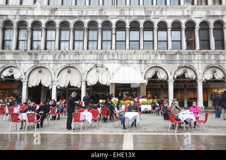 Des gens assis sur une terrasse de restaurant dans Procuratie Vecchie sur la Piazza San Marco à Venise, Italie. Banque D'Images