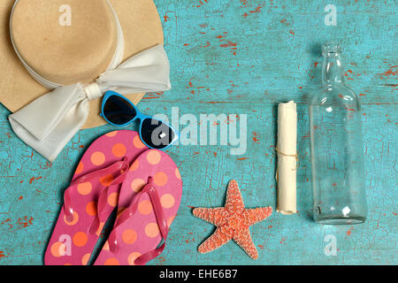 Vintage table avec des articles tels que chapeau, lunettes de soleil, tongs, étoiles et message en bouteille Banque D'Images