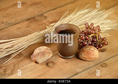 Les éléments de la communion avec le vin, Brad, le blé, le raisin et la tasse sur la table vintage avec du soleil effet flair Banque D'Images