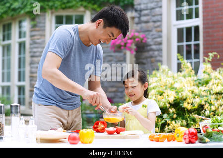 Père et fille dans la cuisine la préparation des aliments Banque D'Images