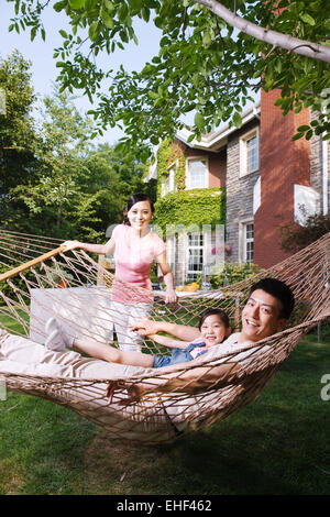 Une famille heureuse de trois dans le jardin Banque D'Images