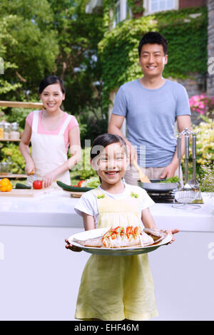 Une famille heureuse de trois ingrédients pour préparer dans la cuisine extérieure Banque D'Images