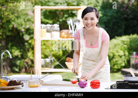 Une femme orientale en cuisine extérieure hacher les légumes Banque D'Images