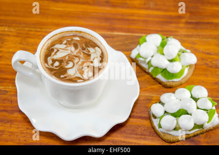 Tasse de café avec de la mousse et décoré avec des biscuits à la crème de kiwi Banque D'Images