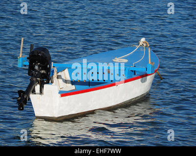 Petit bateau en bois avec moteur hors bord flotte à travers les vagues du lagon bleu Banque D'Images