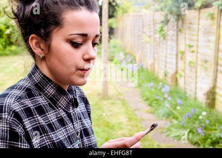 Fille modèle sorti fumer un joint. Banque D'Images