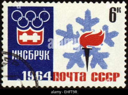 Urss - circa 1964 : un post de timbres en URSS montre emblème olympique et avec la flamme de la torche Banque D'Images