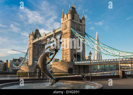 Fille de sculpture et de dauphins sur la rive nord de la Tamise en face du Tower Bridge à Londres, UK - EDITORIAL UTILISEZ UNIQUEMENT Banque D'Images