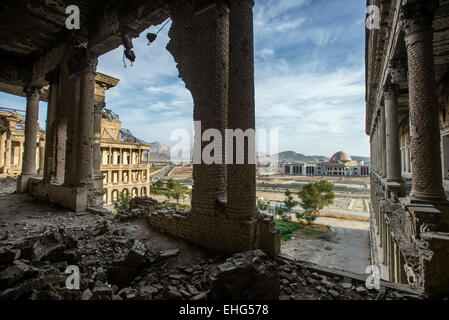 Couloir ruiné de Darul Aman Palace lors de factions moudjahidin s'affrontent pour le contrôle de Kaboul au début des années 1990 et la construction de nouvelles parlement sur l'arrière-plan, Kaboul, Afghanistan Banque D'Images