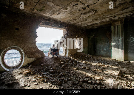 Toxicomane homme posant afghane dans le hall des ruines, Darul Aman Palace à Kaboul, Afghanistan Banque D'Images