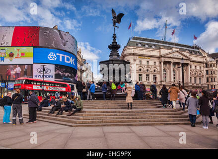 Piccadilly Circus, Londres, Angleterre, avec la statue d'Eros, des foules de touristes et un bus de Londres rouge, sur une journée d'hiver ensoleillée. Banque D'Images