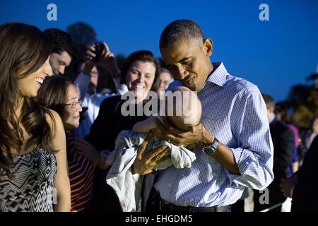 Le président américain Barack Obama est titulaire d'un bébé pendant le pique-nique du Congrès à la Maison Blanche le 17 septembre 2014 à Washington, DC. Banque D'Images