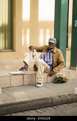 Cuba Santa Clara personnes âgées vieux barbu aux cheveux gris gris baseball cap bag on trottoir chaussée Banque D'Images