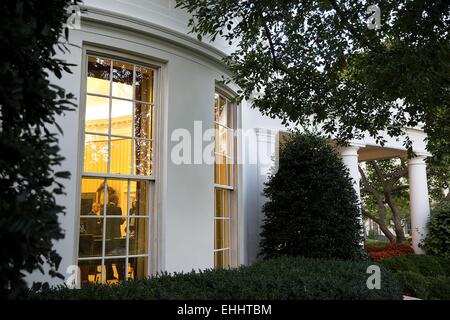 Le président américain Barack Obama parle avec Katie Bernie Fallon, Directeur des affaires législatives, et John Podesta, Conseiller du Président dans le bureau ovale de la Maison Blanche le 8 octobre 2014 à Washington, DC. Banque D'Images