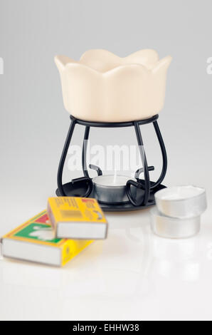 Diffuseur d'huile de cire de pétales de crème, bougies chauffe-plat et boîtes d'allumettes Banque D'Images