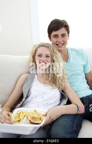 Teen couple eating Burgers and Fries Banque D'Images