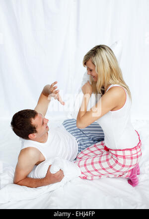 Young couple having a pillow fight Banque D'Images