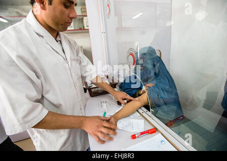 Gestionnaire de laboratoire Hekmatullah Sadate attire le sang de femme portant burqa pour prise de sang en laboratoire de l'hôpital central de la Société afghane du Croissant-Rouge, Kaboul, Afghanistan Banque D'Images