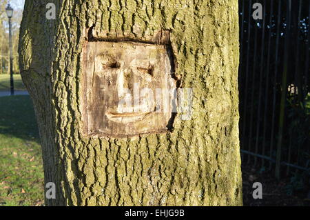 Un visage heureux canalisée sur le corps d'un arbre Banque D'Images