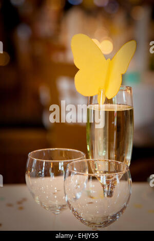 La disposition des verres à champagne et un papillon de papier à un mariage Banque D'Images